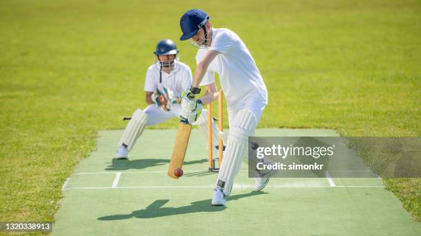 batsman hitting ball on pitch - cricket stock pictures, royalty-free photos & images