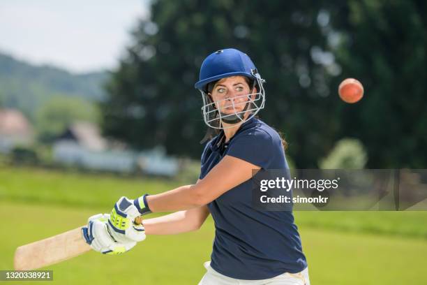 female cricket player hitting the ball with her bat - women cricket stock pictures, royalty-free photos & images