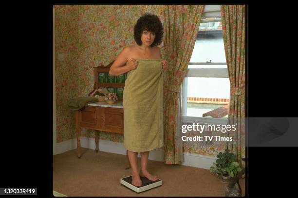 Actress Jill Gascoine weighing herself at home, circa 1984.