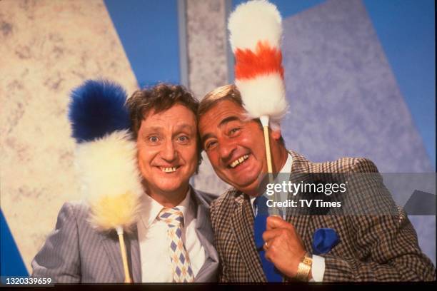 Entertainers Ken Dodd and Bernie Winters posed with 'tickle stick' props during an appearance on game show 3-2-1, circa 1986.