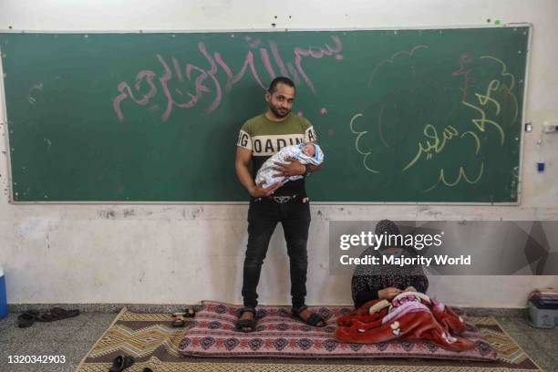 Gaza City. 21st May 2021. A Palestinian family bearing a one-day-old baby at a United Nations school where many displaced Palestinian families have...