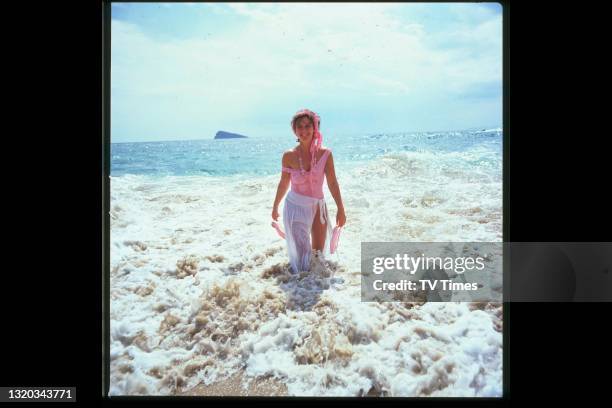 Actress Amanda Burton photographed walking in the surf along a beach in Benidorm, Spain, circa 1984.