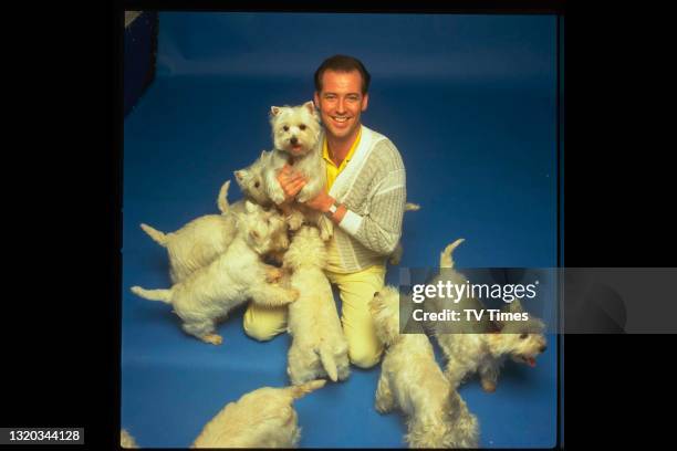 Television presenter Michael Barrymore photographed with a group of West Highland Terrier dogs, circa 1987.