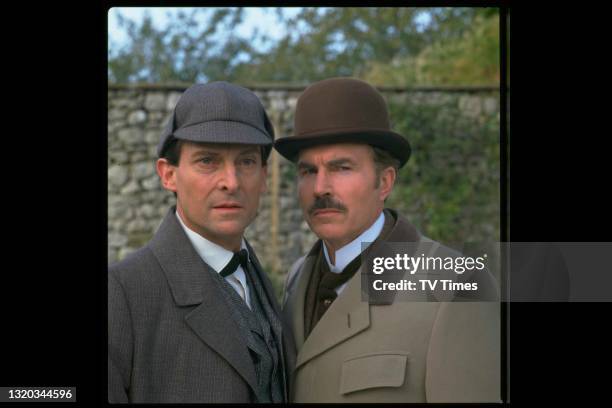 Actors Jeremy Brett and David Burke in character as Sherlock Holmes and Dr. John Watson on the set of The Adventures of Sherlock Holmes, circa 1984.