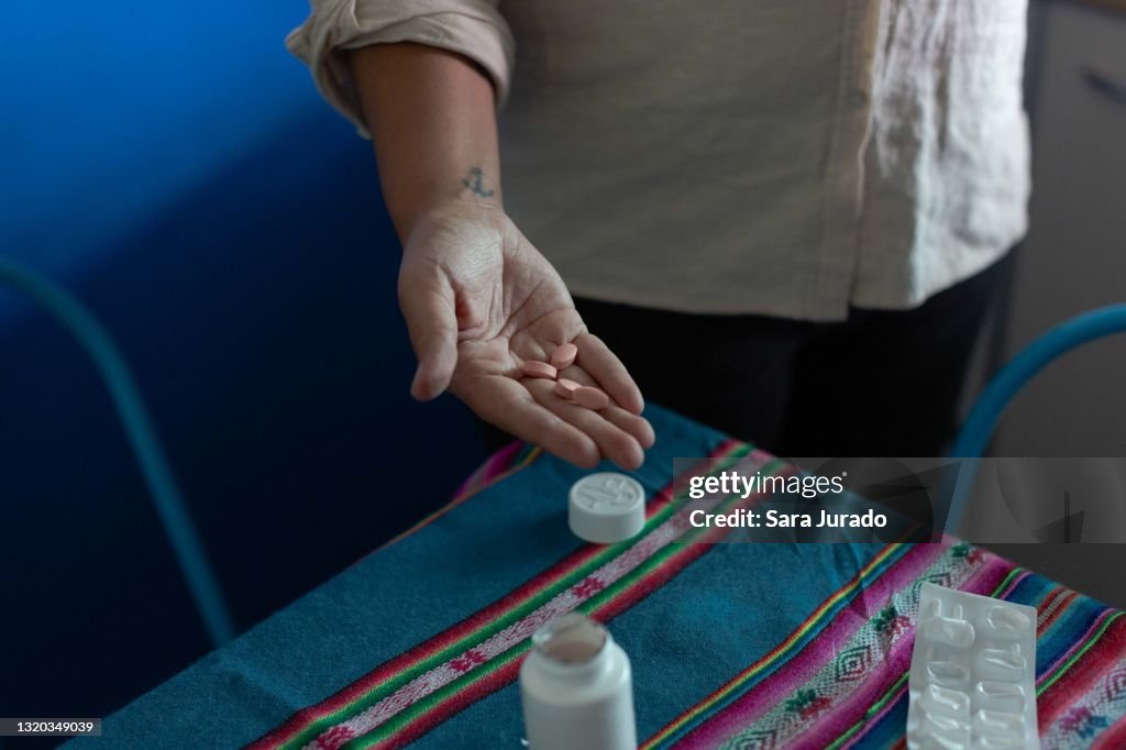 Young latina woman taking medicine