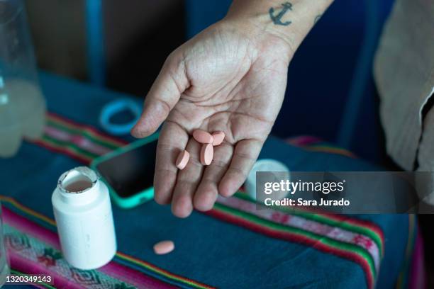 young latina woman taking medicine - hiv imagens e fotografias de stock