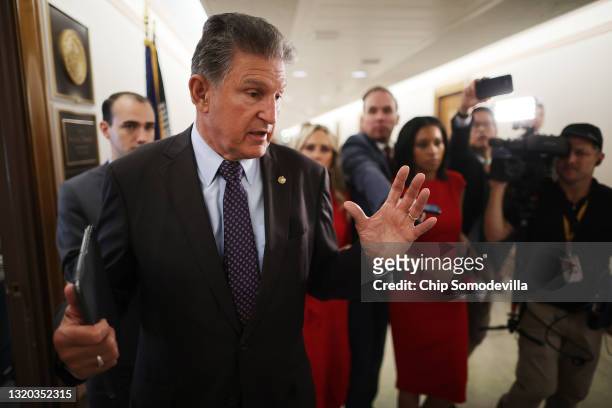 Sen Joe Manchin talks to reporters about his support for a January 6 commission while walking down the hall of the Dirksen Senate Office Building on...