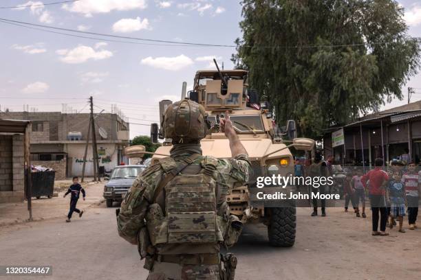 Army soldier guides an armored vehicle under a live wire while on a joint patrol with local allied forces on May 25, 2021 near the Turkish border in...