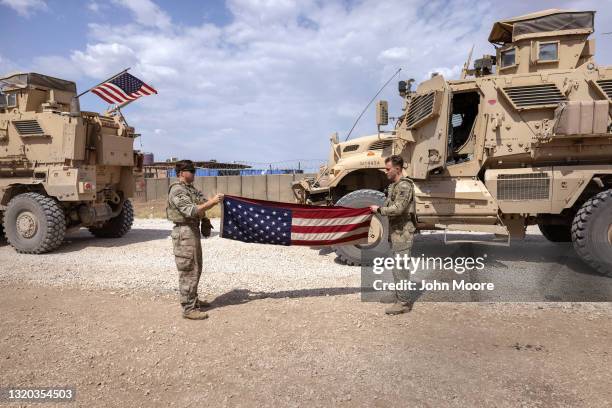 Soldiers fold a flag after returning from patrol to a remote U.S. Army combat outpost known as RLZ on May 25, 2021 in northeastern Syria. U.S....