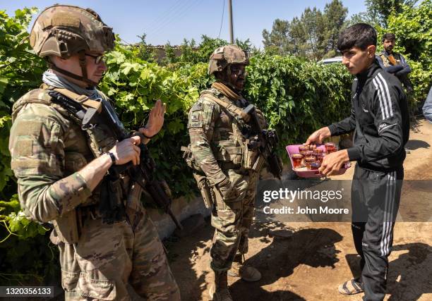 Army soldier declines the offer of tea as his commanding officer and allied troops meet with local villagers on May 26, 2021 near the Turkish border...