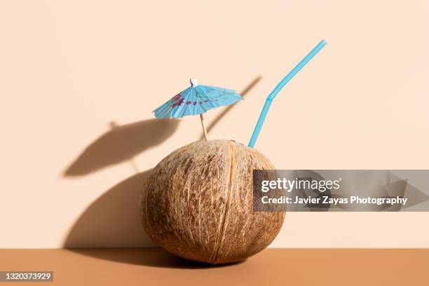 fresh coconut, drink umbrella and straw - kokosnuss stock-fotos und bilder