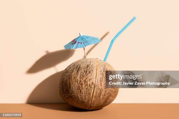 fresh coconut, drink umbrella and straw - coconut water stock pictures, royalty-free photos & images