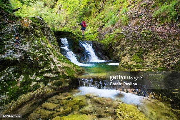 adult hiker on an adventurous hike through the canyon with fantastic waterfalls ,gačnik, soča river, primorska, julian alps. slovenia, europe - triglav slovenia stock pictures, royalty-free photos & images