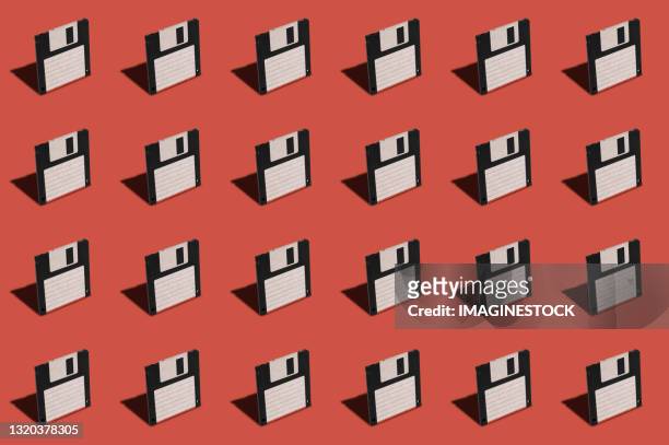 floppy disks pattern on red background - mix photo illustration stock-fotos und bilder