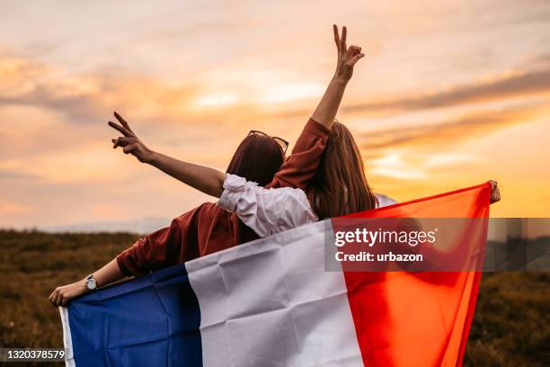 två kvinnor som täcker sig med frankrikes flagga på ängen - french flag bildbanksfoton och bilder