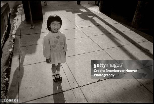 Portrait of a smiling young girl in Chinatown, Oakland, California, 1989.