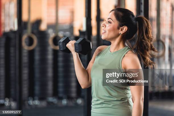 profiel mening krachtige medio volwassen vrouw gewichtheffen bij gymnastiek - gewichtheffen krachttraining stockfoto's en -beelden