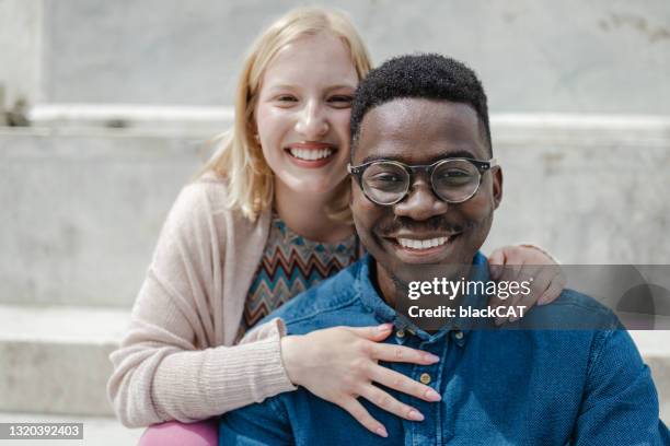 close up portrait of a happy multi-ethnic couple embracing on the street - albino stock pictures, royalty-free photos & images