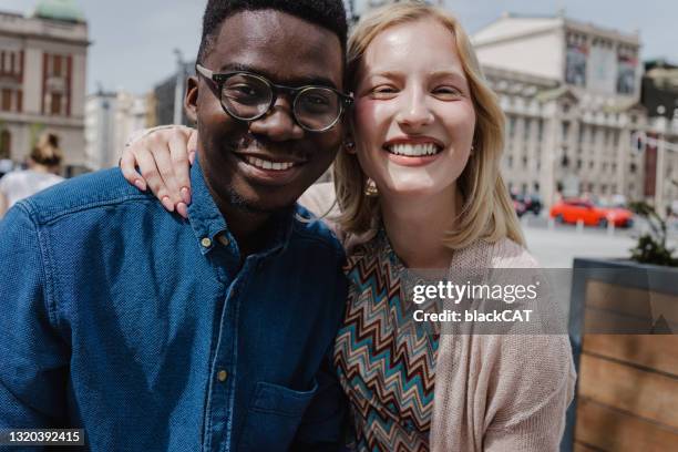 close up portrait of a happy multi-ethnic couple embracing on the street - couple close up street stock pictures, royalty-free photos & images