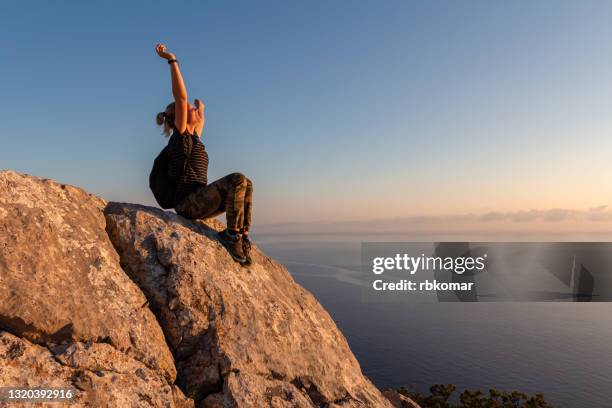 the concept of independence, freedom and motivation. winner girl on top of the mountain - women rock climbing stock pictures, royalty-free photos & images