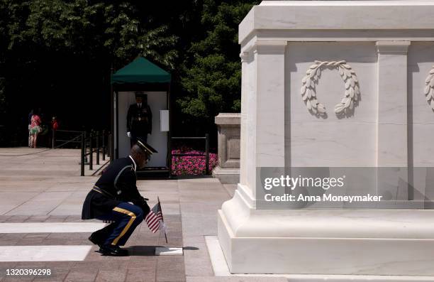 Service member places a flag at the Tomb of the Unknown Soldier as part of the “Flags In” ceremony ahead of the Memorial Day weekend at Arlington...