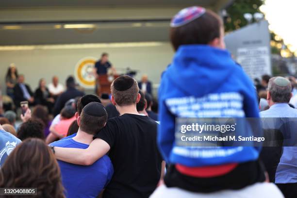 People listen to Joseph Borgen, a recent victim of a hate crime, speak during a rally denouncing anti-Semitic violence on May 27, 2021 in Cedarhurst,...