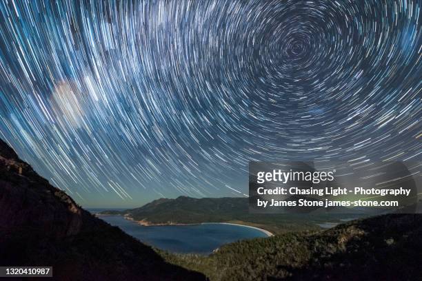 star trail and aurora over wineglass bay - aurora australis stock pictures, royalty-free photos & images