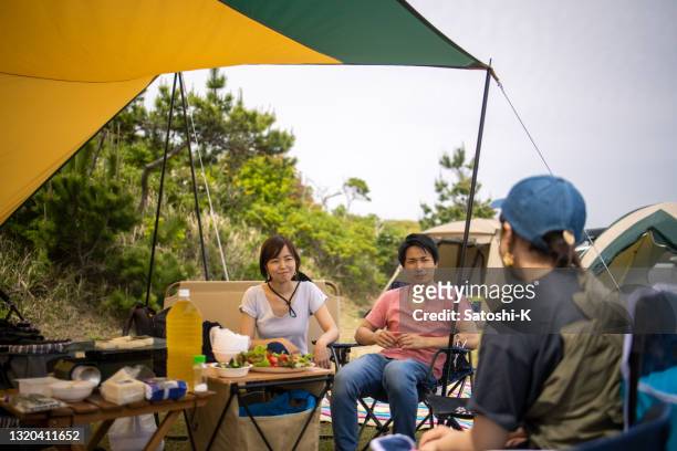 jóvenes hablando en el campamento - tarpaulin fotografías e imágenes de stock