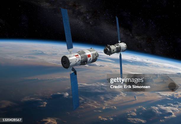 china's (prc) tiangong space station (foreground), as the shenzhou spacecraft with chinese taikonauts aboard approaches for docking in orbit above earth. - space station stock pictures, royalty-free photos & images