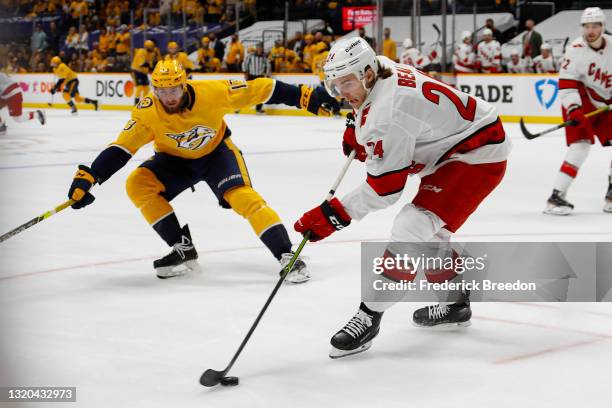 Jake Bean of the Carolina Hurricanes handles the puck against Yakov Trenin of the Nashville Predators during the third period in Game Six of the...