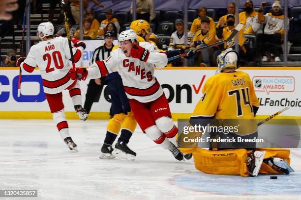 Sebastian Aho and Brock McGinn of the Carolina Hurricanes celebrate scoring a goal against goalie Juuse Saros of the Nashville Predators to win 4-3...