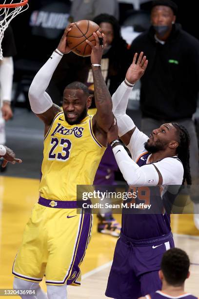 LeBron James of the Los Angeles Lakers rebounds past Jae Crowder of the Phoenix Suns during the second half of Game Three of the Western Conference...