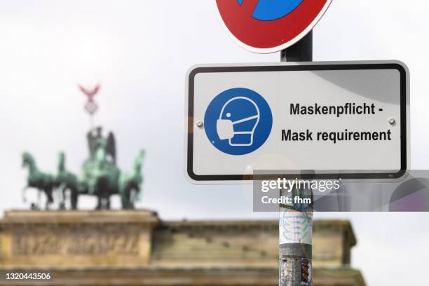 information sign "corona mask requirement" with brandenburg gate amd quadriga statue - quadriga statue brandenburg gate stock-fotos und bilder