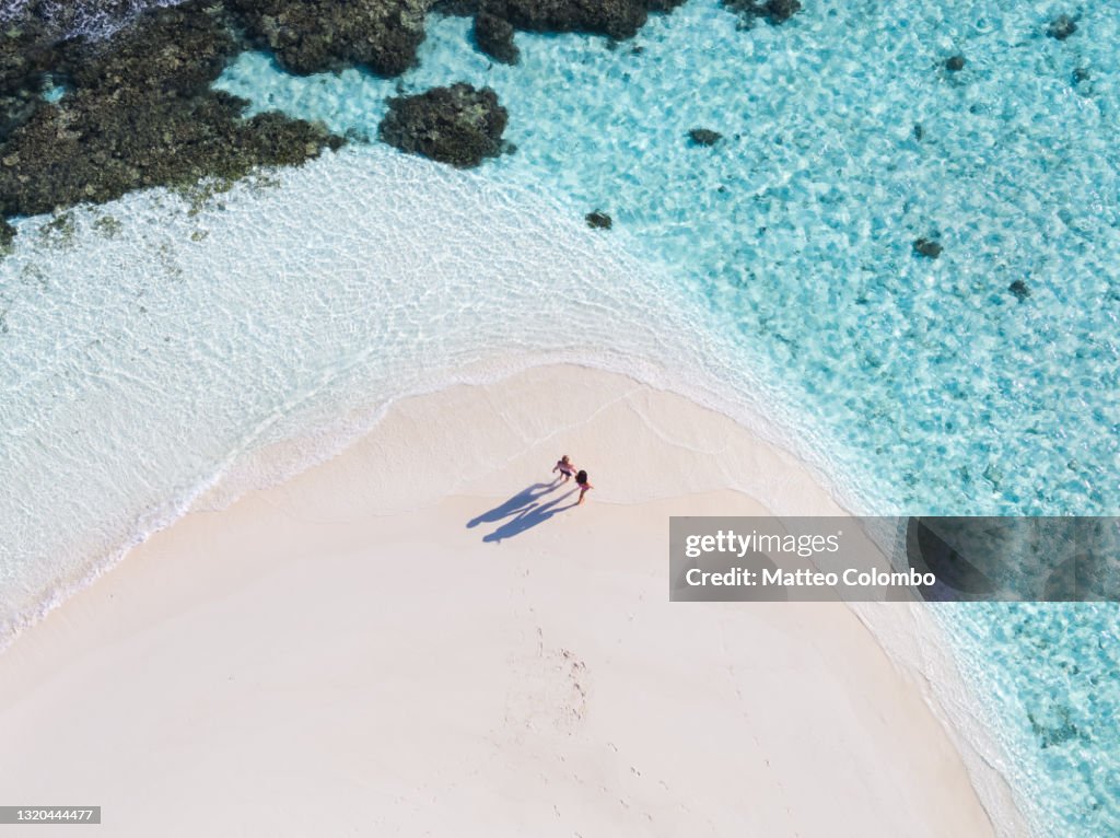 Drone view of adult couple on a beach, Maldives
