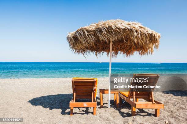 sunchairs and sunshade on beach in the mediterranean - grekiska övärlden bildbanksfoton och bilder
