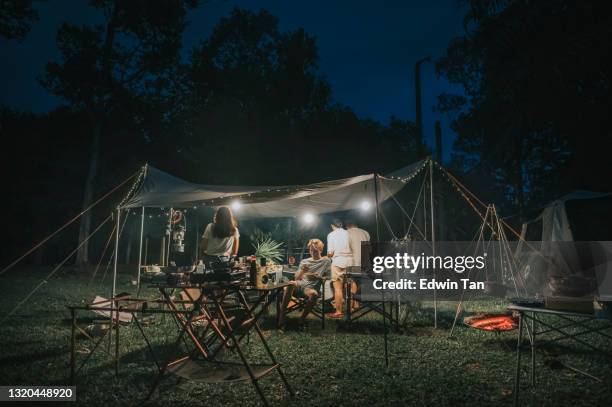 asiatische chinesische familie camping abendessen mit kessel über lagerfeuer brennholz kochend mit rauch und hitze - hot summer nights film stock-fotos und bilder