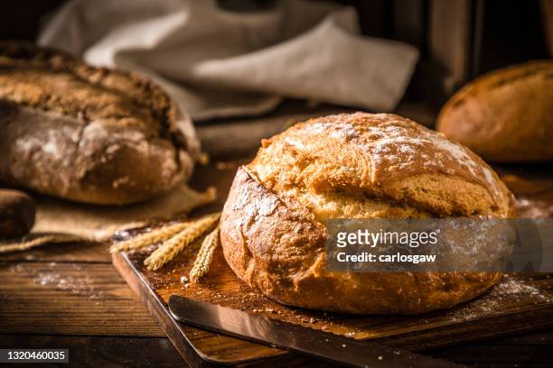 brödlimpa på ett rustikt träbord - artisan food bildbanksfoton och bilder