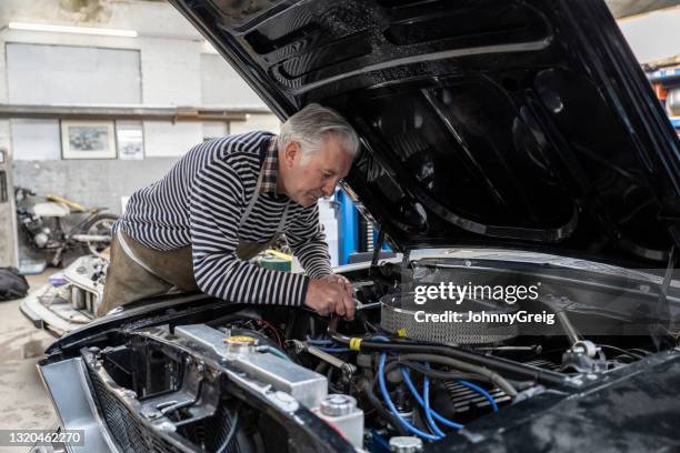 early 60s professional car restorer working under the hood - old car garage stock pictures, royalty-free photos & images