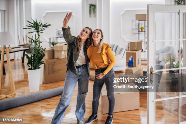 coppia lesbica che si trasferisce in una nuova casa - lgbt mobile foto e immagini stock