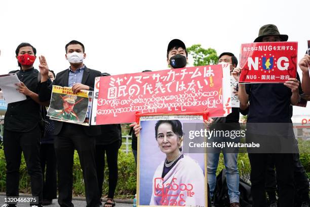 Myanmar people residing in Japan shouts their slogan holding the sign that read 'This national team is not representing our citizens' and a portrait...
