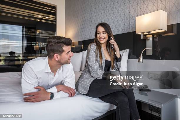 young content couple in room of modern hotel - confort at hotel bedroom stock pictures, royalty-free photos & images