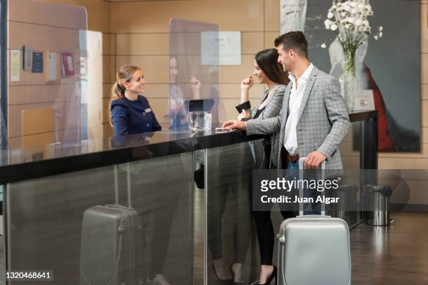 smiling couple of travelers checking in hotel - checking in at hotel stock-fotos und bilder