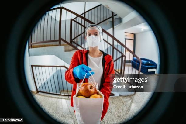 woman delivering groceries during lockdown - looking through hole stock pictures, royalty-free photos & images