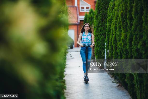 young woman driving electric scooter - mobility scooter stock pictures, royalty-free photos & images