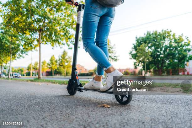 close up on woman feet standing on the electric kick scooter - trotinete imagens e fotografias de stock