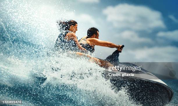 het jonge paar jetskiën. - motorboot varen stockfoto's en -beelden