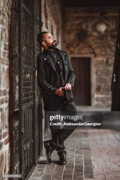 male aristocrat in elegant clothing standing in front of house door - aristocracy stock pictures, royalty-free photos & images