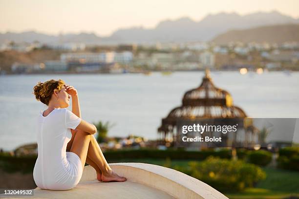 young woman standing on roof and enjoying sunset - sharm el sheikh stockfoto's en -beelden