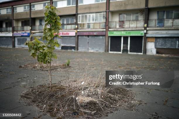 Broken windows and shuttered shops blight the landscape in Collyhurst on May 28, 2021 in Manchester, England. A row of derelict shops and homes in...