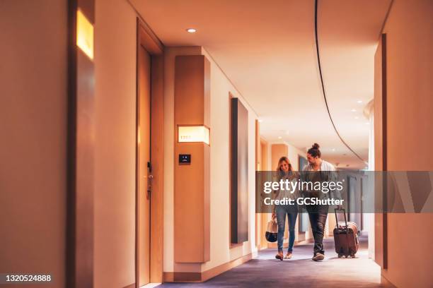 pareja caminando por el pasillo de un hotel de lujo - hospitality fotografías e imágenes de stock